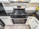 Close-up of a stainless steel gas range in a kitchen with white cabinets and black countertops at 3150 Stratford Green Pl, Avondale Estates, GA 30002