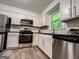 Bright kitchen featuring stainless steel appliances, white cabinets, and wood-look floors at 3150 Stratford Green Pl, Avondale Estates, GA 30002