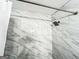 A shower with white marble tiling from floor to ceiling and a silver shower head at 3150 Stratford Green Pl, Avondale Estates, GA 30002