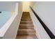 Stairway with carpeted steps and dark wood handrail at 3150 Stratford Green Pl, Avondale Estates, GA 30002