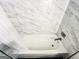 Close-up of a bathtub featuring sleek fixtures and faux marble tiles at 3150 Stratford Green Pl, Avondale Estates, GA 30002