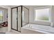 Bright bathroom featuring a soaking tub and a separate glass-enclosed shower with modern fixtures at 185 Discovery Lake Dr, Fayetteville, GA 30215