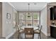 Cozy dining area with a round table, four chairs, a modern chandelier, and natural light from the windows at 185 Discovery Lake Dr, Fayetteville, GA 30215