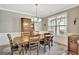 Elegant dining room with a wooden table, chairs, hutch, chandelier, and natural light at 185 Discovery Lake Dr, Fayetteville, GA 30215