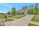 Well-manicured front yard with long drive, a charming home featuring an American flag and lush landscaping at 185 Discovery Lake Dr, Fayetteville, GA 30215