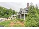 Backside exterior view showing stone accents, large balcony and deck, lawn and a fenced in pool at 185 Discovery Lake Dr, Fayetteville, GA 30215