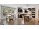 Open-concept kitchen with dark wood cabinets, light countertops, a dining area with a round table, and hardwood flooring at 185 Discovery Lake Dr, Fayetteville, GA 30215