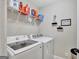 Efficient laundry room with a front-load washer and dryer, shelving, and ample space for storage at 185 Discovery Lake Dr, Fayetteville, GA 30215