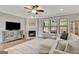 Comfortable living room featuring a fireplace, hardwood floors, ceiling fan, and plenty of natural light at 185 Discovery Lake Dr, Fayetteville, GA 30215