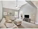 A spacious room with neutral paint and carpet with a ceiling fan, comfortable sofa, and an ottoman at 185 Discovery Lake Dr, Fayetteville, GA 30215