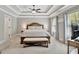 Main bedroom with tray ceiling, ceiling fan, a bed with a bench and two windows for natural light at 185 Discovery Lake Dr, Fayetteville, GA 30215
