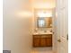 Bright bathroom featuring a wooden vanity, white countertop and decor; the bathroom door is slightly ajar at 280 Ridgemont Dr, Fayetteville, GA 30215