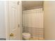 Clean bathroom showcases toilet and shower with neutral-toned shower curtain; white walls and door at 280 Ridgemont Dr, Fayetteville, GA 30215