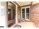 Cozy front porch with brick facade, bench seating, and glass storm door entrance at 280 Ridgemont Dr, Fayetteville, GA 30215