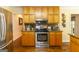 Well-lit kitchen featuring wooden cabinets, granite countertops, stainless steel appliances, and hardwood floors at 280 Ridgemont Dr, Fayetteville, GA 30215