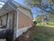 Side of a brick house with a downspout and some overgrown greenery in the yard at 7128 Lady Heidi Ct, Jonesboro, GA 30236