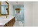 Modern bathroom featuring a glass shower, light blue tile, and stylish vanity with gold accents at 2944 Braithwood Ne Ct, Atlanta, GA 30345