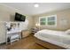Bright bedroom with a bed, vanity with a lighted mirror, and a window letting in natural light at 2944 Braithwood Ne Ct, Atlanta, GA 30345