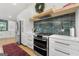 Kitchen features stainless steel oven and refrigerator, green backsplash and hood with white cabinets at 2944 Braithwood Ne Ct, Atlanta, GA 30345