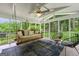 Cozy screened-in porch with swinging daybed, ceiling fans, and view of the lush backyard at 2944 Braithwood Ne Ct, Atlanta, GA 30345
