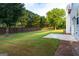 Expansive backyard featuring lush green grass, a concrete patio, and a privacy fence at 8750 Redford Ln, Suwanee, GA 30024