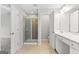 Spacious bathroom featuring tiled floors, a glass shower and a vanity with double sinks at 8750 Redford Ln, Suwanee, GA 30024