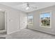 Carpeted bedroom with two windows, ceiling fan and a double door closet for storage at 8750 Redford Ln, Suwanee, GA 30024