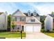 Charming two-story home featuring a brick and gray siding exterior with a two-car garage and well-manicured lawn at 8750 Redford Ln, Suwanee, GA 30024