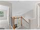 Second floor hallway with decorative railing provides views of the living room below at 8750 Redford Ln, Suwanee, GA 30024