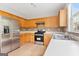 Modern kitchen featuring stainless steel appliances, wooden cabinets, and laminate floors for a clean and functional space at 8750 Redford Ln, Suwanee, GA 30024