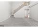 Bright living room with staircase features neutral colors and plush gray carpeting at 8750 Redford Ln, Suwanee, GA 30024