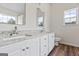 Bathroom featuring double sinks, granite countertops, white cabinets, wood floor, and natural light at 501 Llewellyn Ct, Jenkinsburg, GA 30234