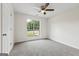 This bedroom features a large window, ceiling fan, and neutral carpet at 501 Llewellyn Ct, Jenkinsburg, GA 30234
