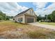 View of home from the side, showing brick facade, attached garage and a partially wooded lot at 501 Llewellyn Ct, Jenkinsburg, GA 30234
