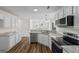 Modern kitchen with stainless steel appliances, granite countertops, and wood floors, perfect for culinary enthusiasts at 501 Llewellyn Ct, Jenkinsburg, GA 30234