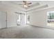 Spacious main bedroom featuring trey ceilings, ceiling fan, large windows, and barn door to bath at 501 Llewellyn Ct, Jenkinsburg, GA 30234