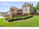 Backyard featuring a stone fireplace, a deck, and a lush lawn with colorful flowers and greenery at 150 Campaign Trl, Fayetteville, GA 30214