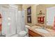 Bright bathroom featuring a glass shower, granite countertop, and decorative framed art pieces on the wall at 150 Campaign Trl, Fayetteville, GA 30214