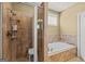 Bathroom showcasing tiled walk-in shower, soaking tub, and neutral color scheme for a relaxing atmosphere at 150 Campaign Trl, Fayetteville, GA 30214