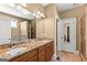 Bathroom featuring granite countertops, double sinks, and a large mirror with views of the bathtub and shower at 150 Campaign Trl, Fayetteville, GA 30214