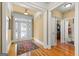 Bright foyer with hardwood floors, glass front door and sidelights, a decorative rug, and an open floor plan at 150 Campaign Trl, Fayetteville, GA 30214