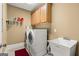 Functional laundry room with a white washer, dryer, utility sink, and ample storage cabinets at 150 Campaign Trl, Fayetteville, GA 30214