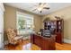 Well-lit home office featuring a classic wooden desk, chair, and shelving unit with bright natural light at 150 Campaign Trl, Fayetteville, GA 30214