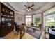 This office features an elegant design, built-in bookcase, and a tray ceiling with a ceiling fan at 825 Chalet Hls, Mcdonough, GA 30253