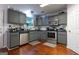 Well-lit kitchen featuring gray cabinets, stainless steel appliances, and hardwood floors at 4613 Beau Point Ct, Snellville, GA 30039