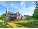 Backyard view highlighting lush lawn, mature trees, the home's architecture and fenced-in area at 145 Seawright Dr, Fayetteville, GA 30215