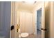 Bright bathroom featuring a toilet, shower with curtain, and doorway leading to other rooms at 145 Seawright Dr, Fayetteville, GA 30215
