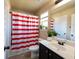 Bright bathroom with a red-striped shower curtain and vanity with ample mirror space at 145 Seawright Dr, Fayetteville, GA 30215