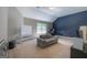 Bright bonus room with grey sofa, whiteboard, and dedicated office area featuring a calming blue accent wall at 145 Seawright Dr, Fayetteville, GA 30215