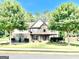 Charming two-story home with stone accents, manicured lawn, and mature trees offering shade and curb appeal at 145 Seawright Dr, Fayetteville, GA 30215